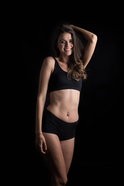 Beautiful woman with healthy body on black background - 写真・画像