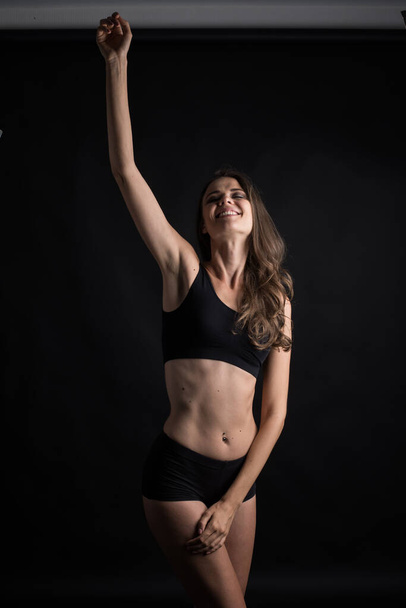 Beautiful woman with healthy body on black background - Foto, Imagem