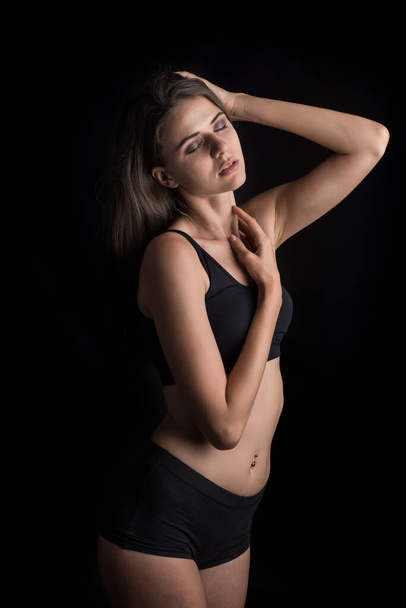 Piękna kobieta ze zdrowym ciałem na czarnym tle - Zdjęcie, obraz