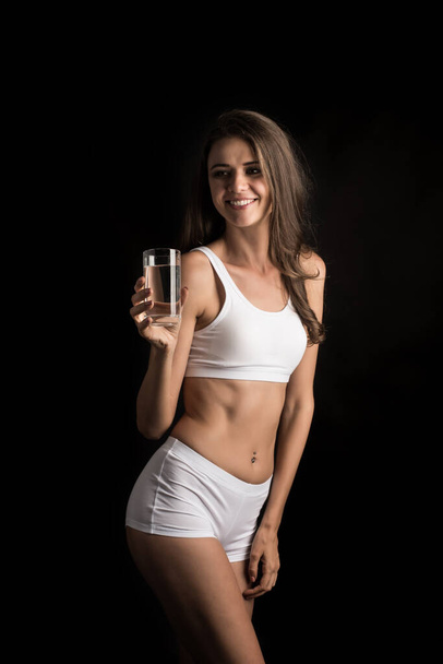 Θηλυκό μοντέλο φυσικής κατάστασης που κρατά ένα ποτήρι νερό - Φωτογραφία, εικόνα