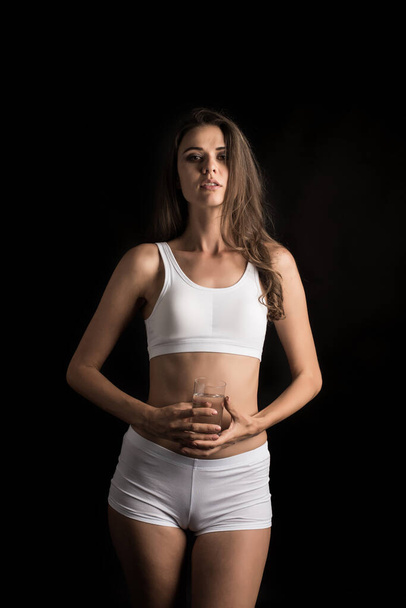Modelo de fitness femenino sosteniendo un vaso de agua
 - Foto, Imagen