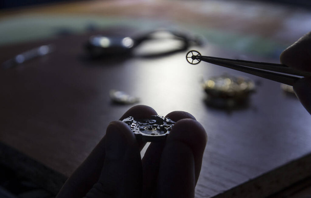 Een horlogemaker repareert een vintage automatisch horloge. - Foto, afbeelding