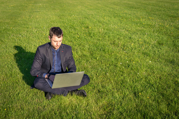 Business outside. Student boy work with laptop, computer tablet in summer park. Online technology with man outdoor. Escaped of office distance education concept - Photo, Image