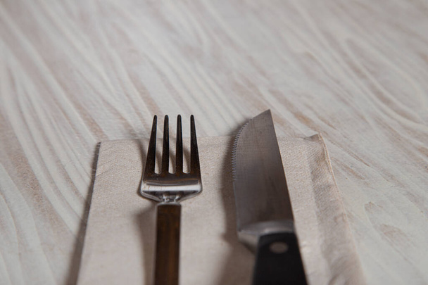 Close up of cutlery on wooden table. Stainless steel fork and knife - Photo, image
