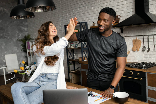 Young couple  giving high five on kitchen  - Foto, Bild