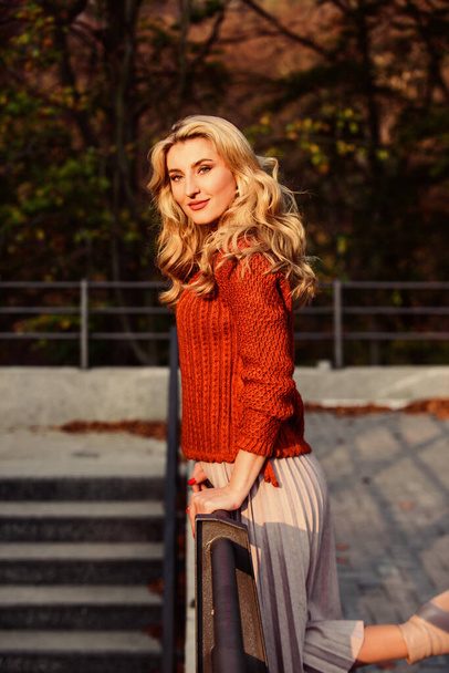 Fashionable clothes. Girl gorgeous blonde. Femininity and tenderness. Autumn stylish outfit. Fall fashion. Adorable lady enjoy sunny autumn. Woman walk in autumn park. Cozy knitwear. Knitted sweater - 写真・画像