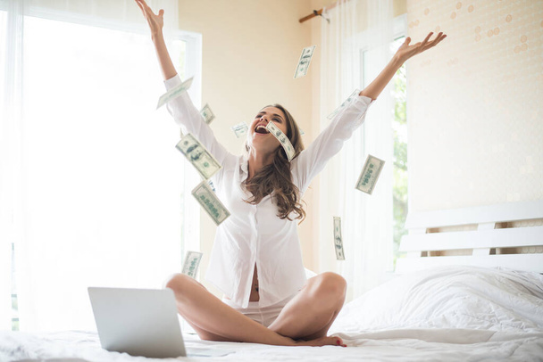 Woman with dollar bank note on the bed - Foto, Bild