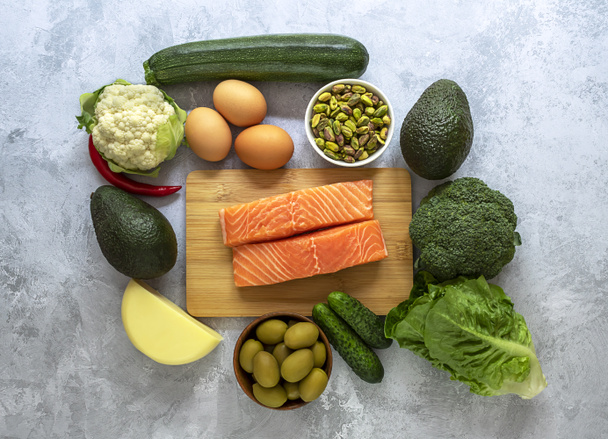 Das keto-Diätkonzept, ketogen mit Gemüse, Eiern, Avocado, Fisch, Nüssen und Öl auf hellem Hintergrund. - Foto, Bild