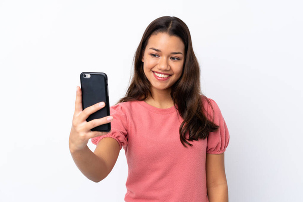 jong Colombiaans meisje over geïsoleerde witte achtergrond het maken van een selfie - Foto, afbeelding