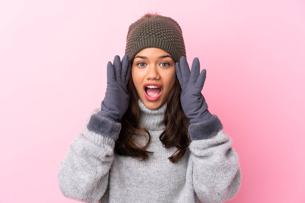 Young Colombian girl with winter hat over isolated pink wall shouting with mouth wide open - Photo, Image