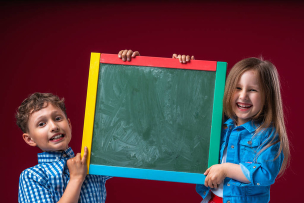 Group of school children boy and girl, Caucasian, elementary age. keep an empty Board for copying space. Back to school. Advertising. - 写真・画像