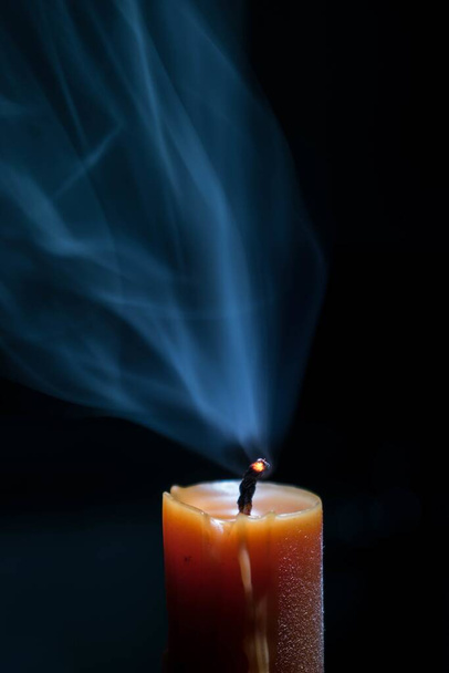 A vertical shot of a burned-out candle isolated on a black background - nice for wallpapers - Photo, Image