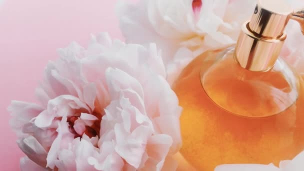 Sitrushedelmien hajuvesipullo pioni kukkia, tyylikäs tuoksu tuoksu ylellisyyttä kosmeettisia, muoti ja kauneus tuotteen tausta - Materiaali, video