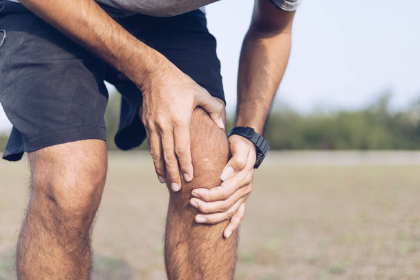 Молодий чоловік травмує коліно під час вправи або бігу
 - Фото, зображення