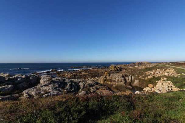 A mesmerizing shot of a beautiful rocky coastline covered in green - Zdjęcie, obraz