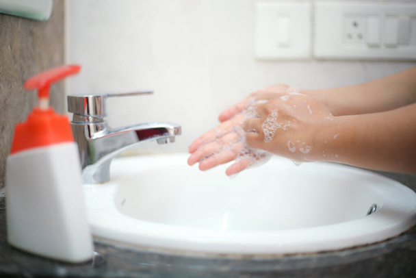 Hände sanft mit Flüssigseife waschen, um Rückenschmerzen und Infektionen vorzubeugen - Foto, Bild