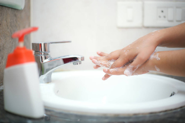 Lavarsi delicatamente le mani con sapone liquido per evitare backterias e infezioni - Foto, immagini