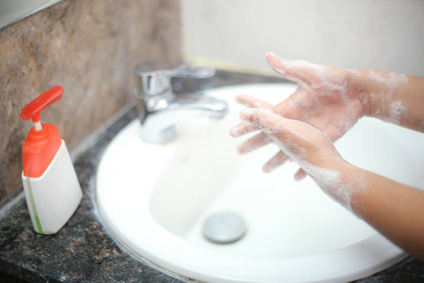 Lavarsi delicatamente le mani con sapone liquido per evitare backterias e infezioni - Foto, immagini