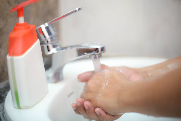 Delikatnie umyć ręce mydłem w płynie, aby zapobiec bakteriom i zakażeniom - Zdjęcie, obraz