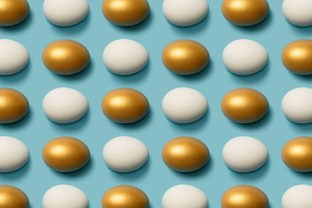 Patrón con huevos blancos y dorados sobre fondo azul. Fondo abstracto
. - Foto, imagen