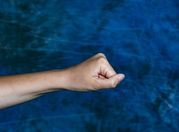 A horizontal shot of a fist from a side on a marbled blue background - Foto, Imagem