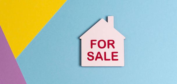 Concepto de casa en venta con casa de papel sobre fondo de colores pastel - Foto, Imagen