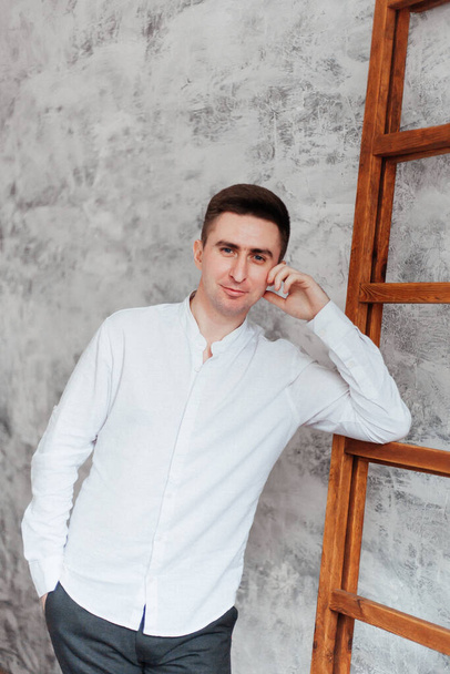 άντρας (αγόρι ή άντρας), επιχειρηματίας, με λευκό πουκάμισο σε φωτογραφείο στο σπίτι - Φωτογραφία, εικόνα