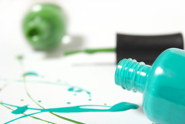 Blauer und grüner verschütteter Nagellack auf weißem Hintergrund - Foto, Bild