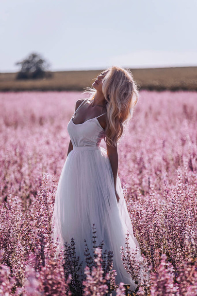 Beautiful woman in pink field - 写真・画像