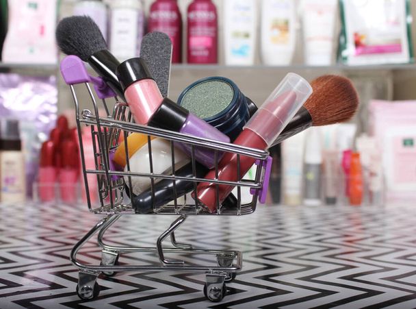 Various Beauty Products in shopping basket with blurred cosmetics in background - Photo, Image