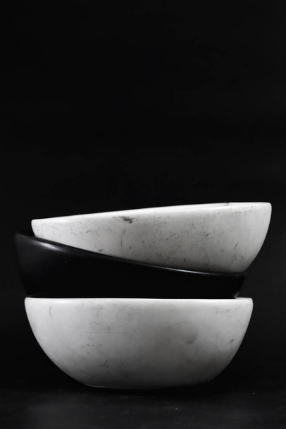 Disposizione di antiche stoviglie in ceramica Bianco e nero sono impilati insieme per renderlo bello. su sfondo nero. - Foto, immagini