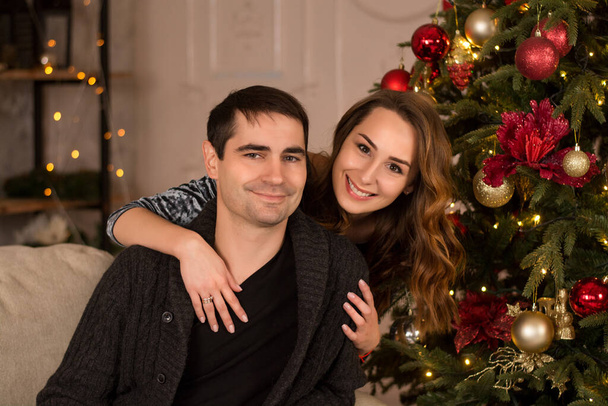 happy young couple with christmas presents. young couple decorating christmas tree at home.  young couple celebrating christmas - Zdjęcie, obraz