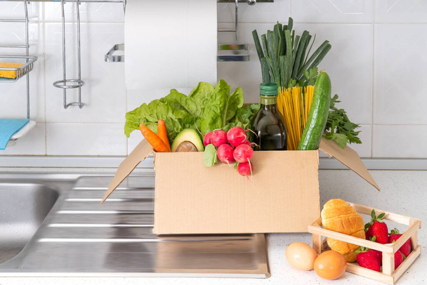 Donation box with superfoods fruits and vegetables. Sharing food concept. Food Delivery Volunteer collecting food. Coronavirus pandemic help. Front view - 写真・画像
