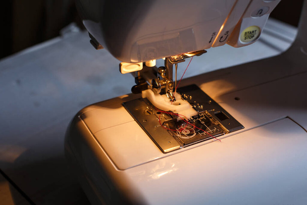 Close-up of a sewing machine with light on. workplace tailor. sewing industry. - Valokuva, kuva