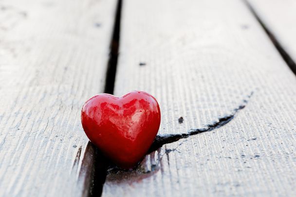 κόκκινη καρδιά στη ρωγμή της ξύλινη σανίδα. σύμβολο της αγάπης - Φωτογραφία, εικόνα