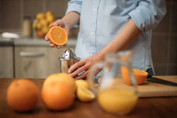 Junge Frau macht Saft aus frischen Orangen zu Hause - Foto, Bild