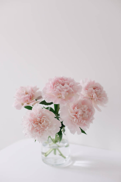 Beautiful pink peonies in a vase at home interior. Flower composition. Floral shop concept. Beautiful fresh cut bouquet. copyspace - 写真・画像