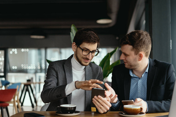 Zwei Geschäftsleute unterhalten sich per Smartphone - Foto, Bild