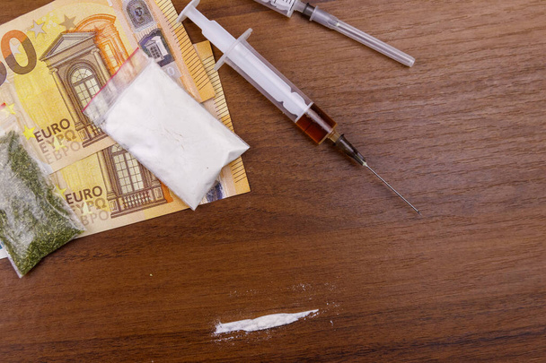 Különböző típusú drogok: kokain, heroin fecskendő, szárított kannabisz és euró az asztalon. Kábítószer-használat, kábítószer-kereskedelem, bűnözés és függőség - Fotó, kép