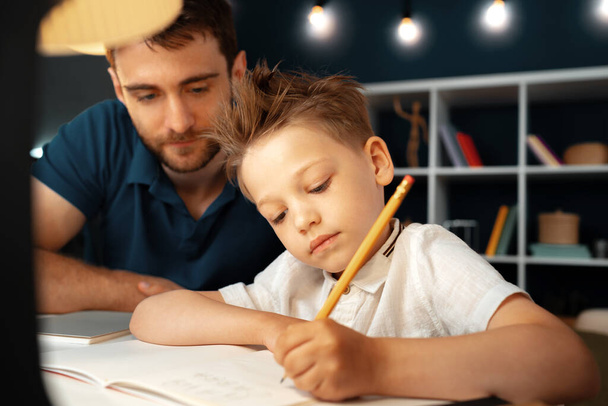 Dad and son doing school homework together - Фото, изображение