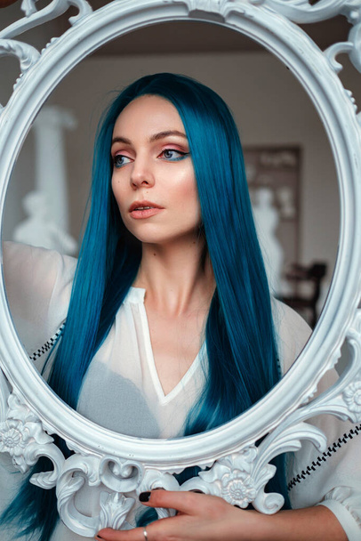 Ritratto di donna dai capelli vivaci e colorati. Colorazione dei capelli, belle labbra e trucco. ragazza sexy con lunghi capelli blu - Foto, immagini