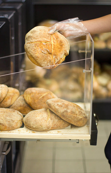 Mano femminile che sceglie il pane al supermercato - Foto, immagini