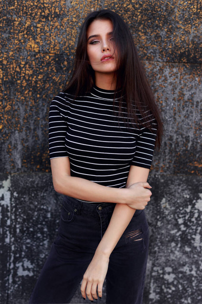 Closeup of a hot young woman with straight brown hair, wear in black clothes, flirt and looking at camera. Vertical view. - Φωτογραφία, εικόνα
