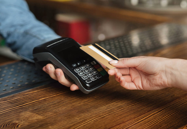 Conta de pagamento rápida e fácil. Cliente paga bebidas com cartão de crédito no terminal
 - Foto, Imagem