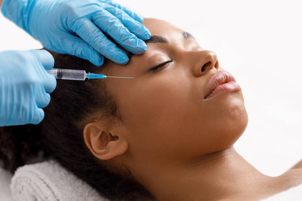 Femme noire se faire injecter des yeux au salon - Photo, image