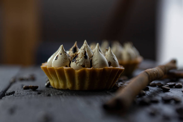 Cappuccino tart with cinnamon sticks and coffee beans on rustic wooden table  - 写真・画像