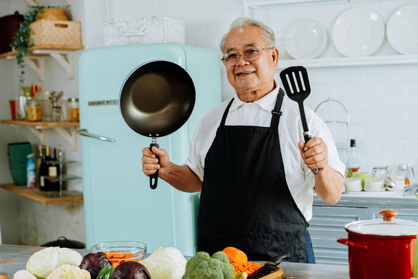 Friendly elderly Asian man with kitchenware - Fotoğraf, Görsel