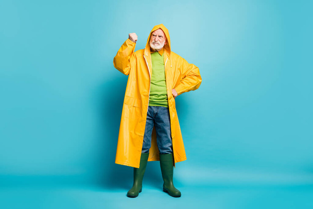 Full length body size view of his he nice dissatisfied quarrelsome grey-haired man wearing yellow topcoat blaming bad weather forecast isolated over bright vivid shine vibrant blue color background - Fotoğraf, Görsel