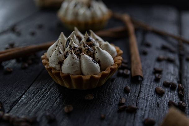 Cappuccino tart with cinnamon sticks and coffee beans on rustic wooden table  - Fotografie, Obrázek