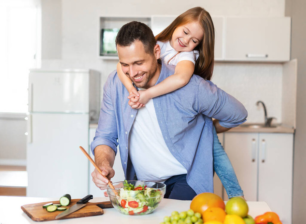 Happy Dad Cooking Holding Little Daughter On Shoulders In Kitchen - Foto, imagen